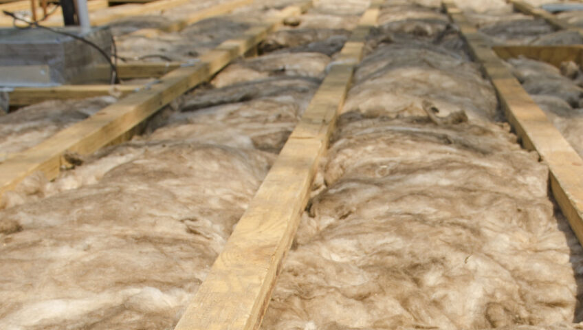 exposed tan insulation in an unfinished attic space